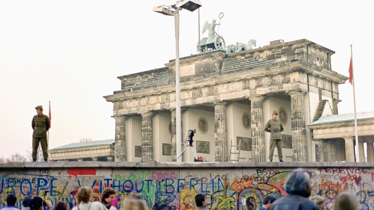 No dia 9 de novembro, o Muro de Berlim no Portão de Brandemburgo é monitorado por dois policiais da Polícia Popular