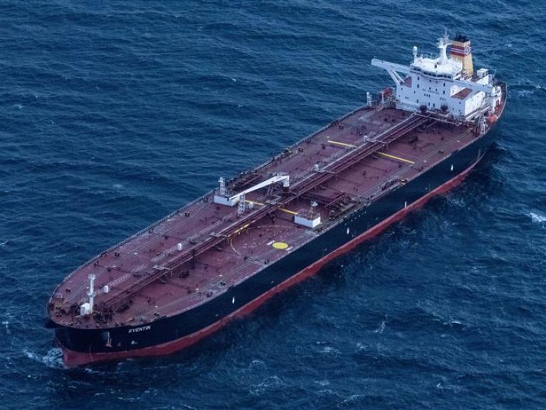 A large cargo ship named “Eventin” sailing on rough open seas. 