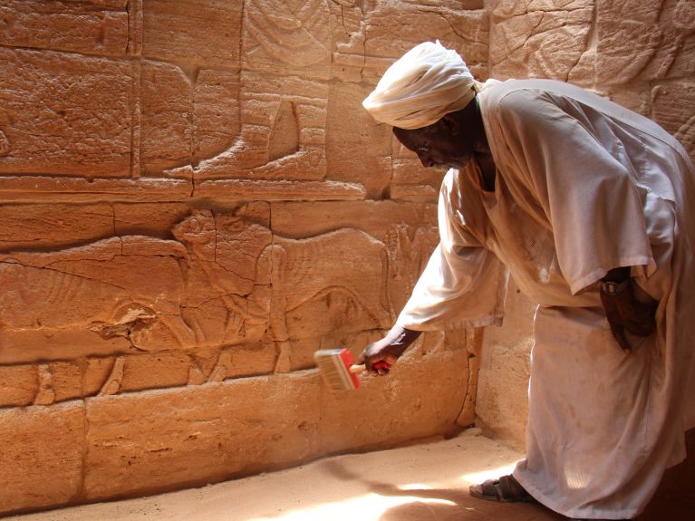 Guard Mustafa Ebeid-Allah cleaning reliefs in Sudan.