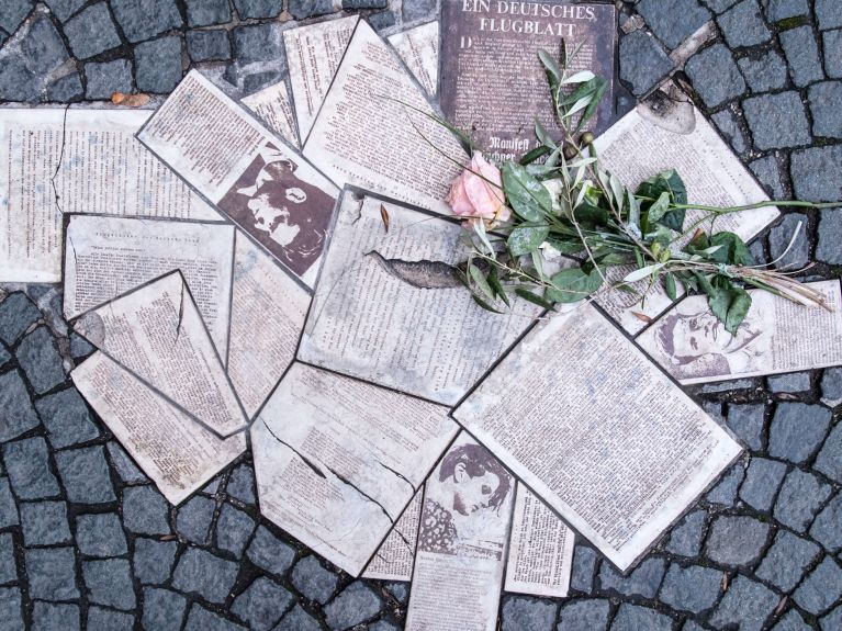 Como um memorial, os panfletos estão incrustados no chão da praça Geschwister-Scholl-Platz