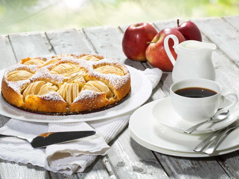 Apple pie, coffee cup and plate, apples on wood