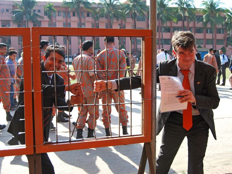 Jochen Weikert (r.) und ein GIZ-Kollege übergeben Ausrüstung an die Feuerwehr in Dhaka.