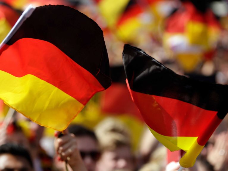 Aficionados al fútbol muestran la bandera de Alemania.