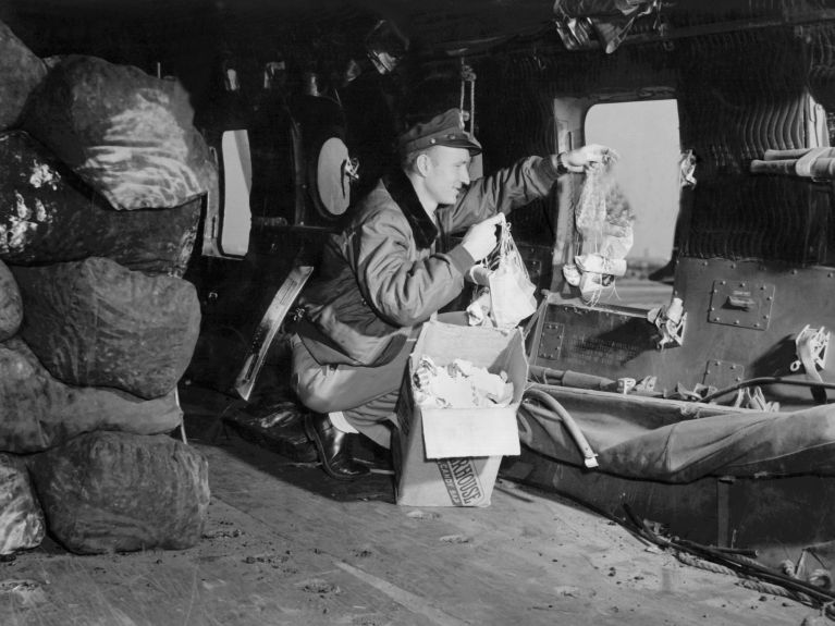 70 Jahre Luftbrücke Berlin: US-Leutnant Gail Halvorsen wirft für die Kinder Süßigkeiten an kleinen Fallschirmen ab.