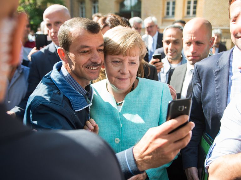 Chancellor Angela Merkel and a refugee in 2015 Chancellor Angela Merkel and a refugee in 2015