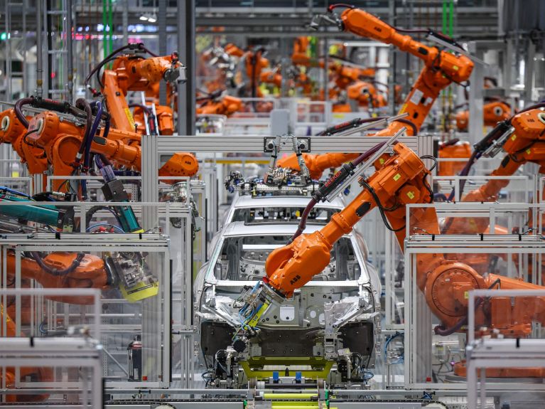 Os robôs industriais fabricam carros.  Os robôs industriais fabricam carros.